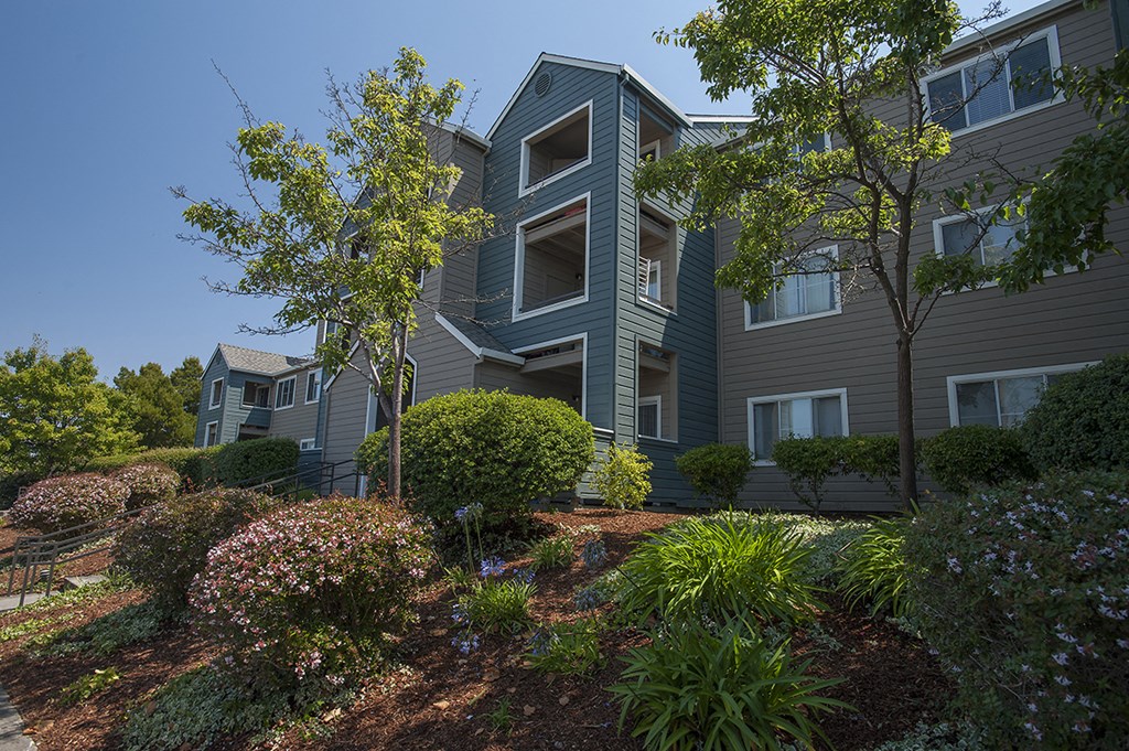 an apartment building with a garden in front of it