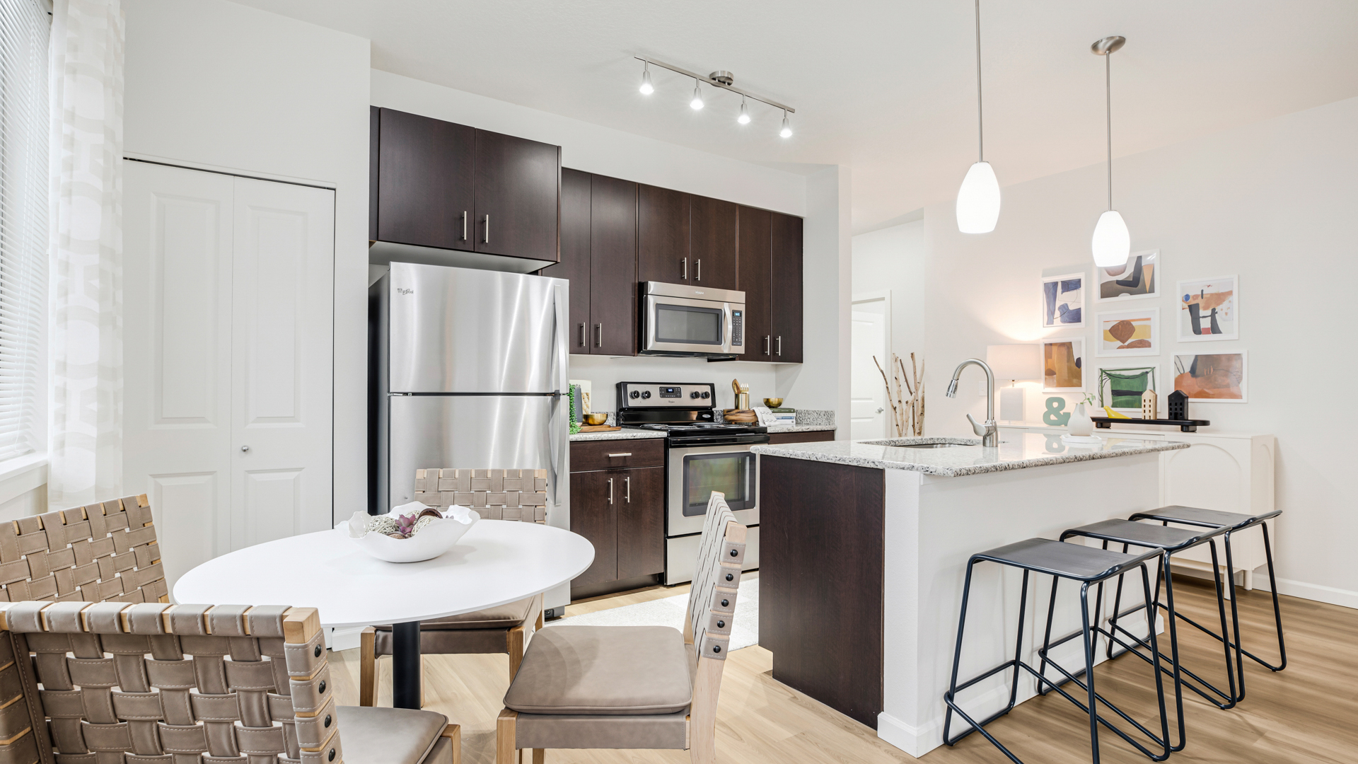 A modern kitchen with a white table and chairs.