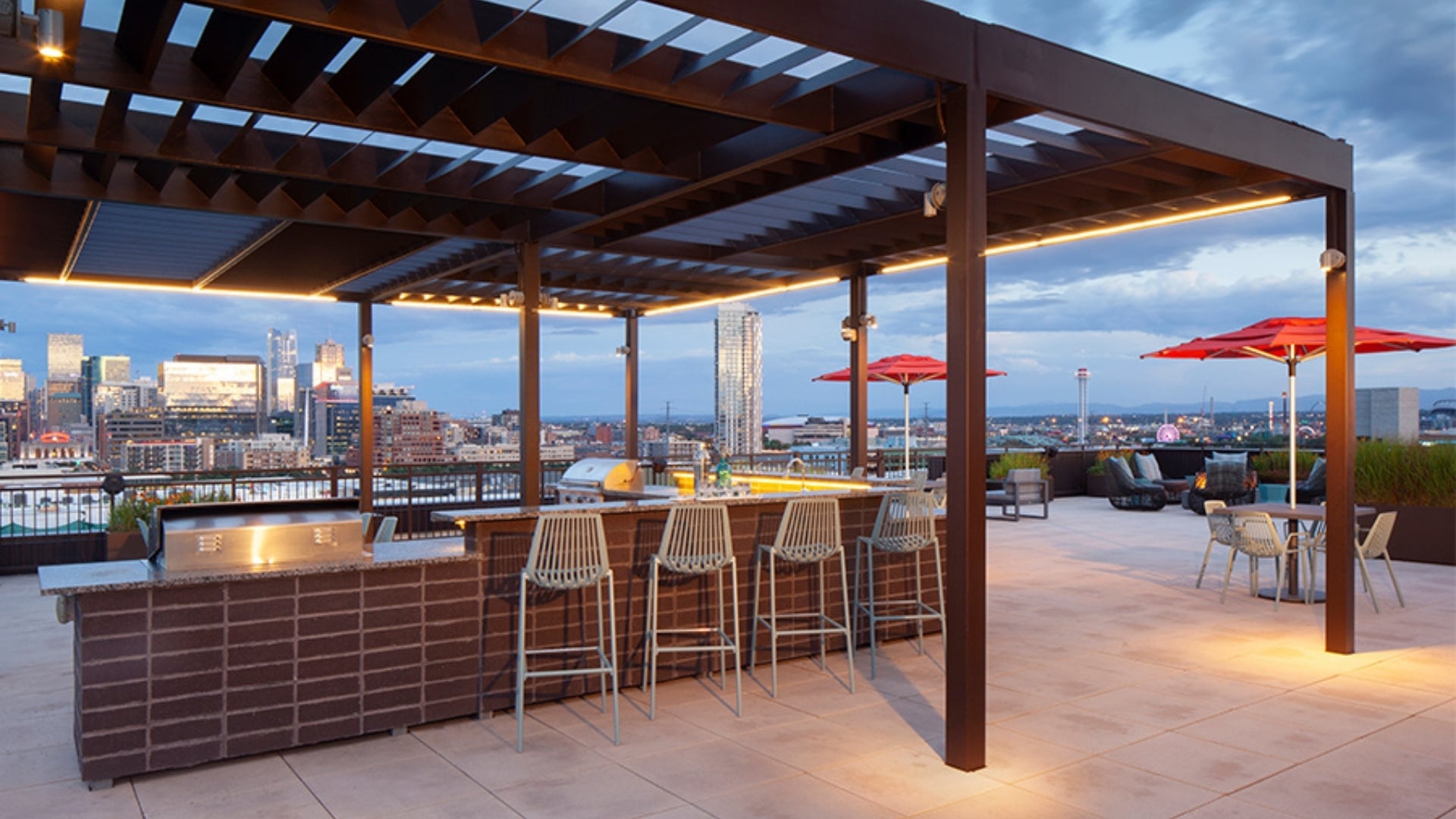 A rooftop bar with a view of the city at dusk.