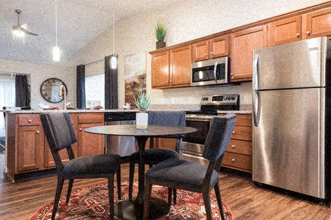 A kitchen with a table and chairs.