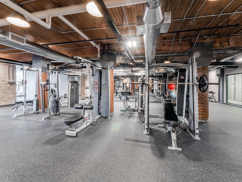 Chicago luxury apartment fitness center gym amenity with treadmills, bikes, boxing punching bags, free weights, and ellipticals