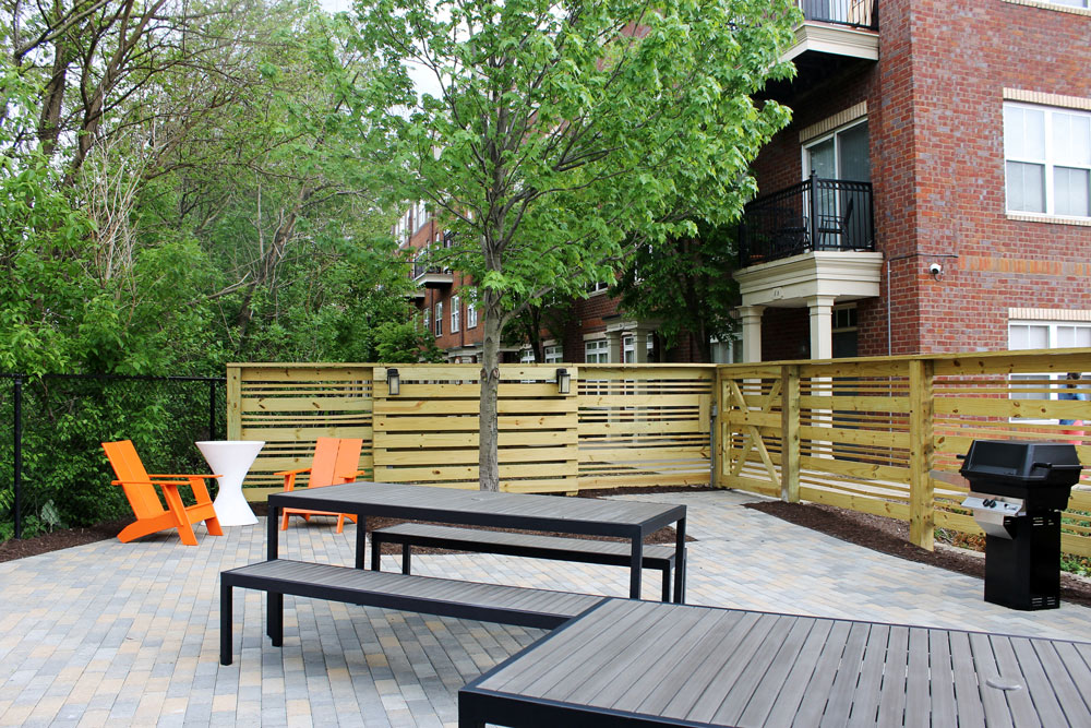 a patio with a wooden fence and a table and chairs