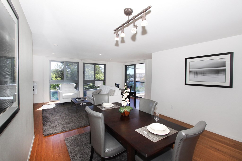 a dining room and living room with a wooden table and chairs