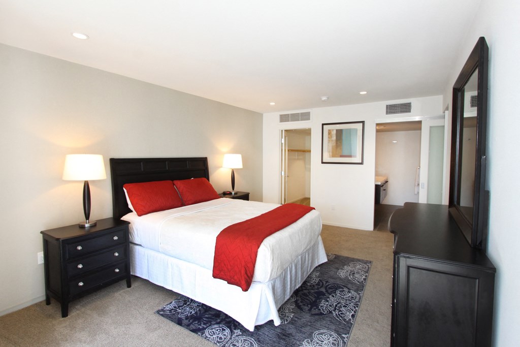 a bedroom with a bed and a mirror in a hotel room