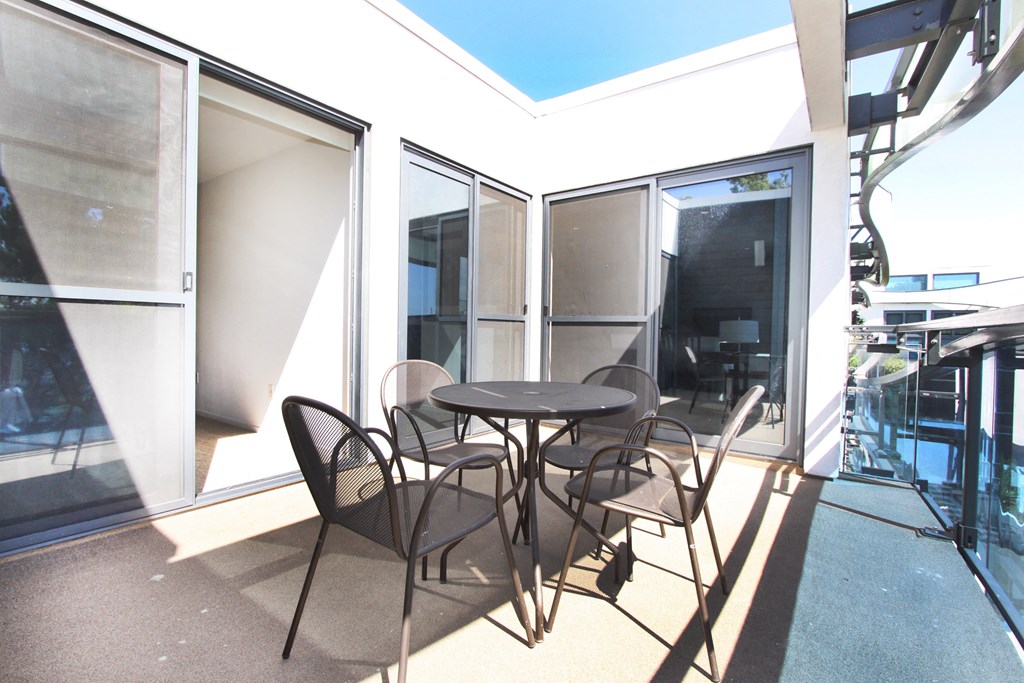 a patio with a table and chairs on a balcony