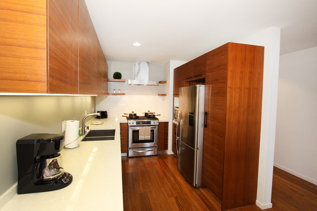 a kitchen with wooden cabinets and a stainless steel refrigerator
