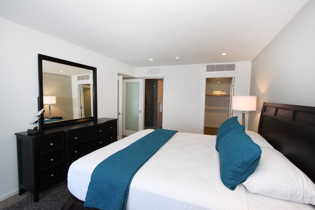 a bedroom with a large bed and a mirror in a hotel room