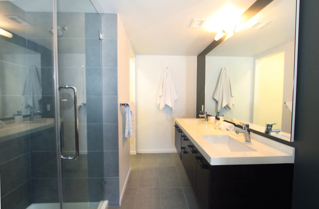 a bathroom with a shower and a sink and a mirror