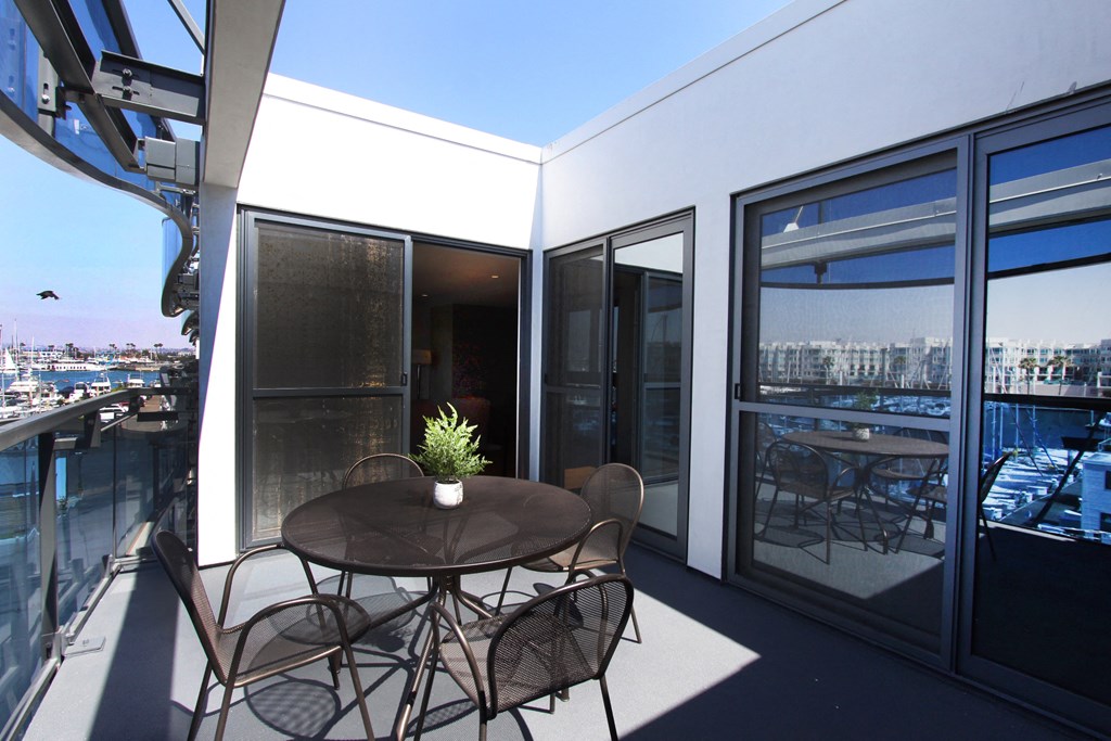 a balcony with a table and chairs and a view of the city