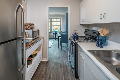 an open kitchen with stainless steel appliances and white cabinets