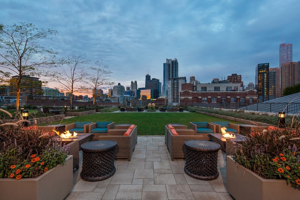 Outdoor fire pits with views of the Chicago skyline and green terrace area at Kingsbury Plaza, Chicago