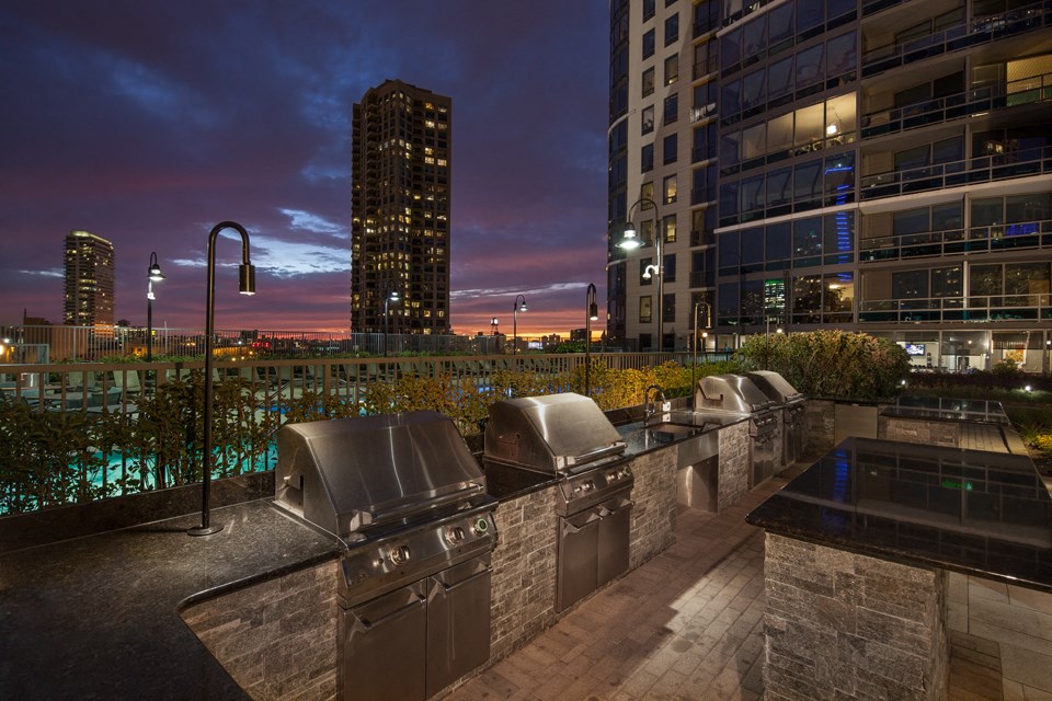 Outdoor grilling area at dusk with slight sunset and Kingsbury Plaza facade in the background at Kingsbury Plaza, Illinois