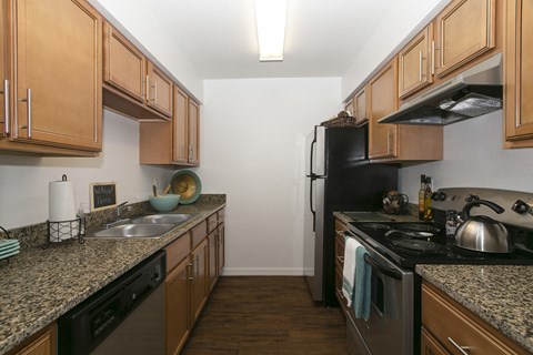 a kitchen with wood cabinets and granite counter tops and a black stove and refrigerator