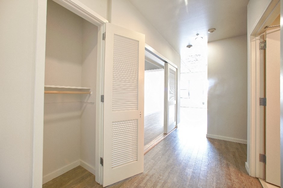 an empty hallway with an open closet door