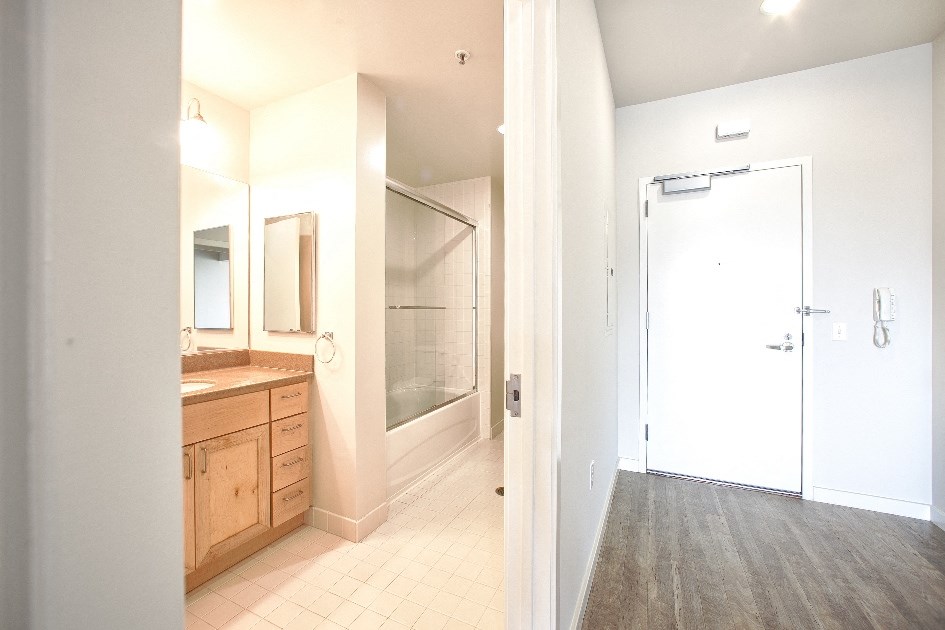a bathroom with a shower and a sink and a door