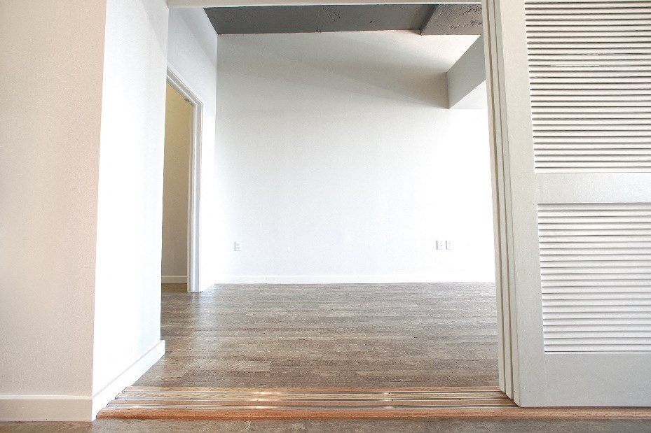 an empty room with white walls and a wood floor