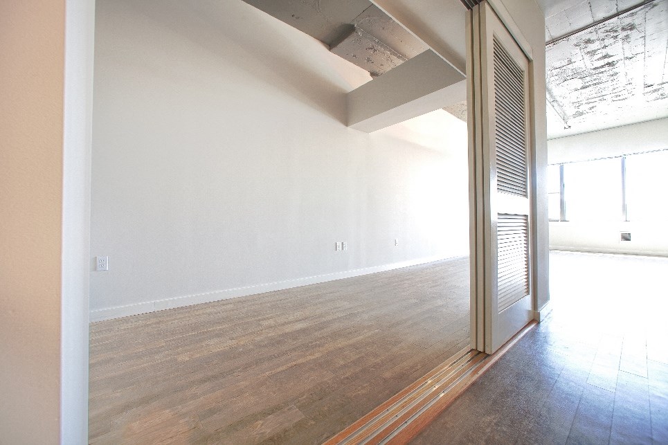 an empty living room with white walls and a wood floor