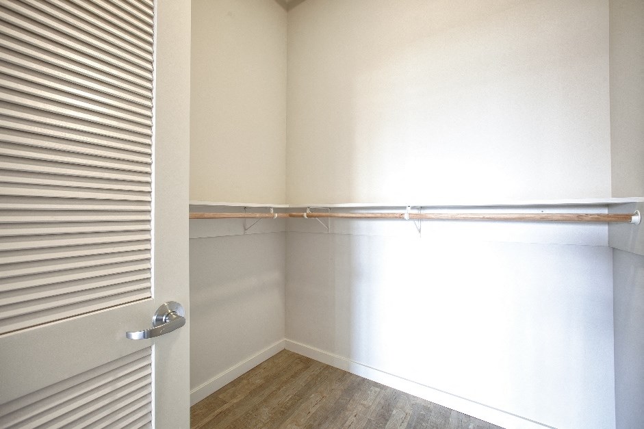 a room with a closet and a window with a curtain