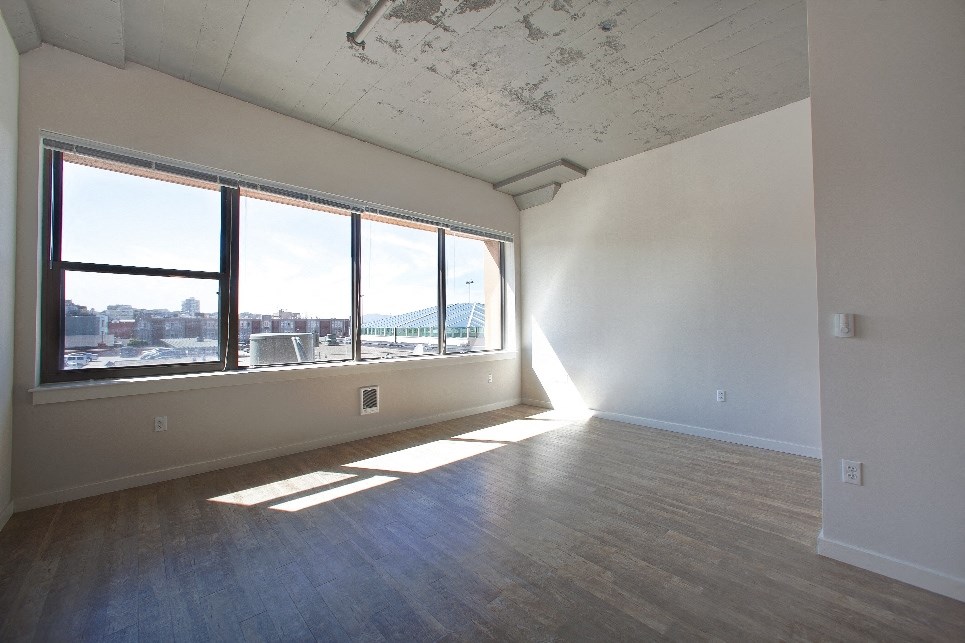 an empty living room with a view of the city and a window