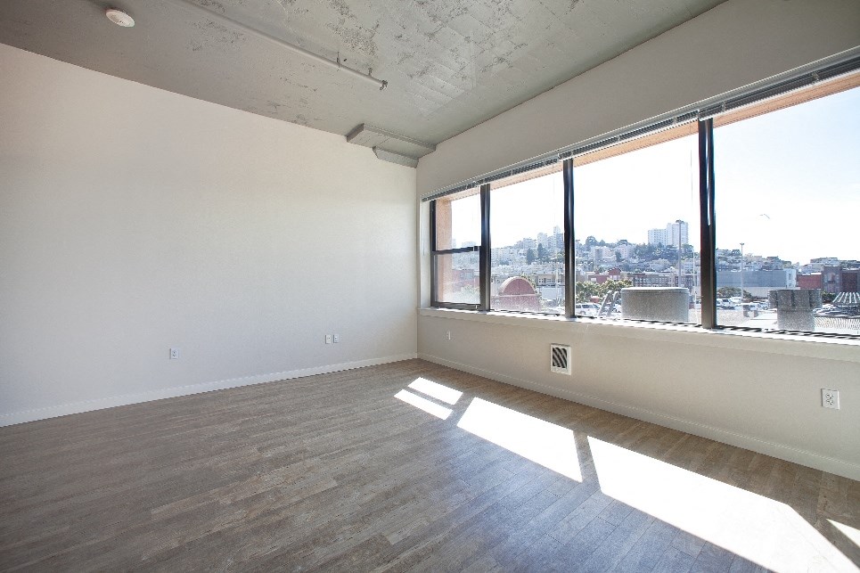 the living room of an empty apartment with a large window