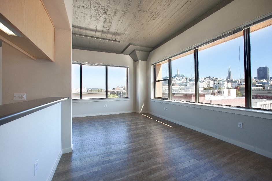an empty living room with a view of the city