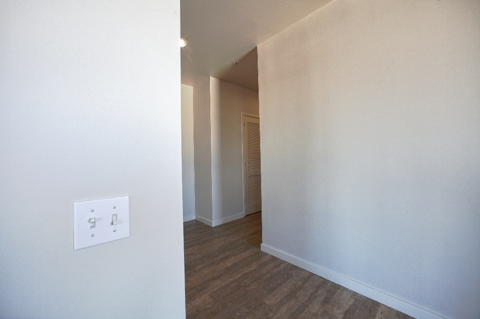the living room and hallway of a renovated house with an outlet on the wall