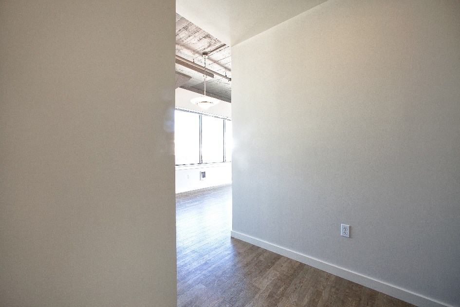an empty room with white walls and a wood floor