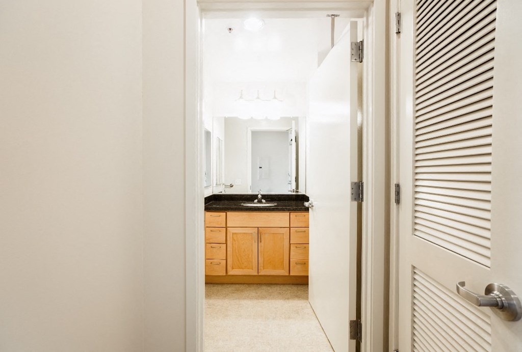 a bathroom with a sink and a mirror and a door