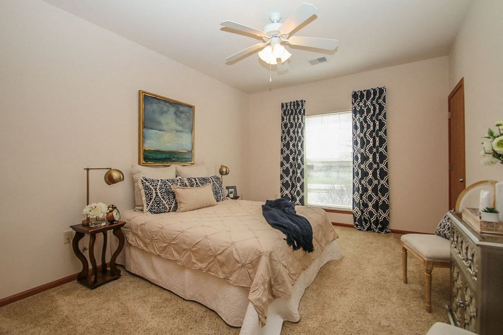 a bedroom with a bed and a ceiling fan