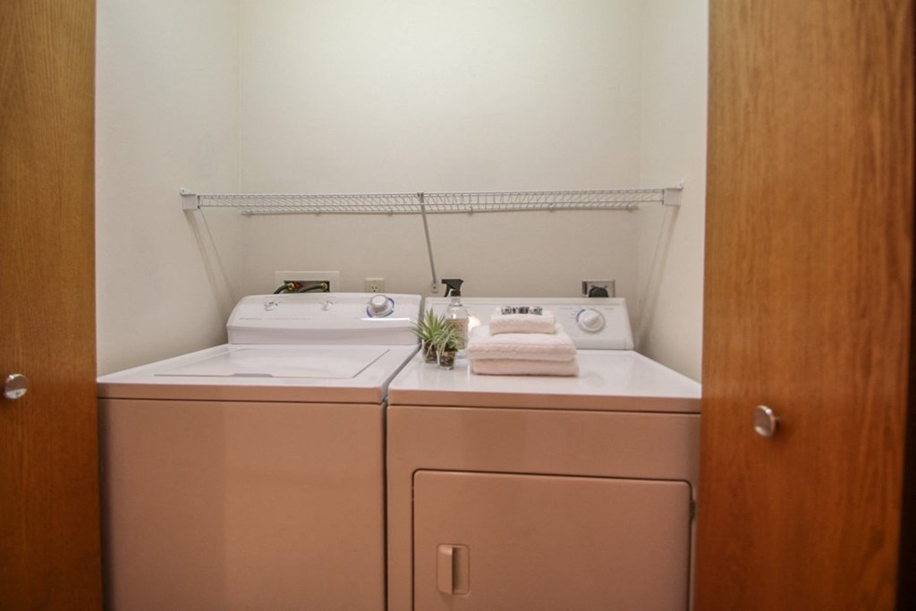a white washer and dryer in a white laundry room