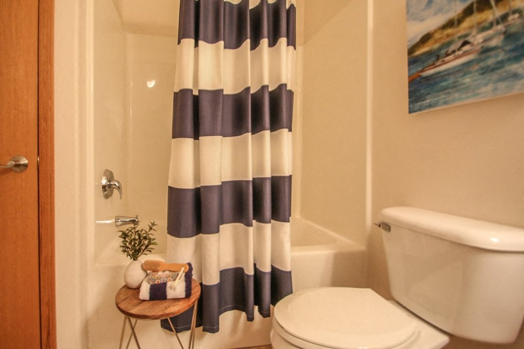 a bathroom with a toilet and a striped shower curtain
