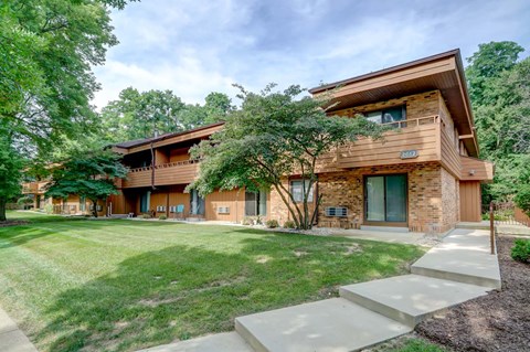 a house with a lawn and trees in front of it