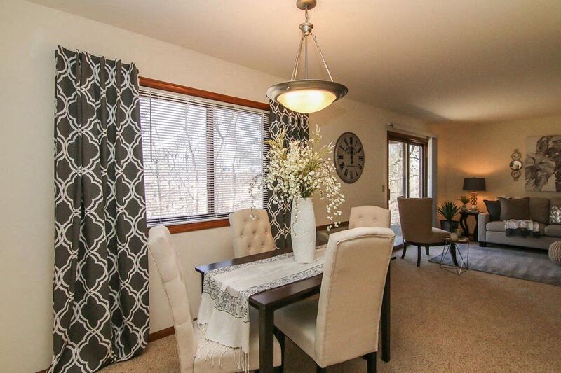 a living room and dining room with a table and chairs