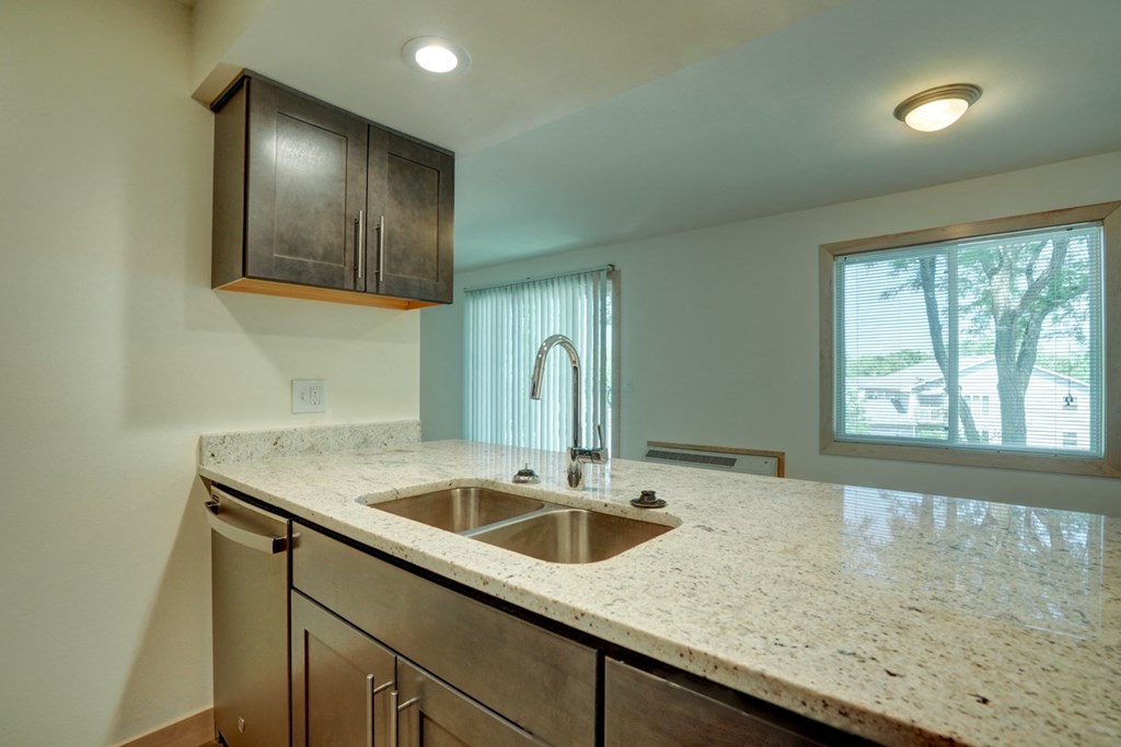 an empty kitchen with a sink and a window