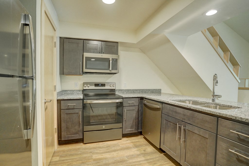 the kitchen of a home with stainless steel appliances and wooden cabinets