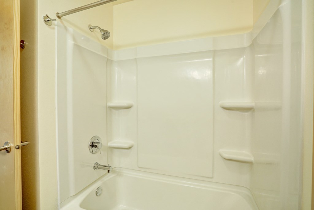 a white bathroom with a shower and a tub