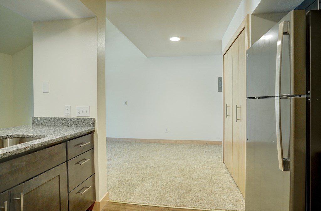 an empty kitchen with a stainless steel refrigerator and sink