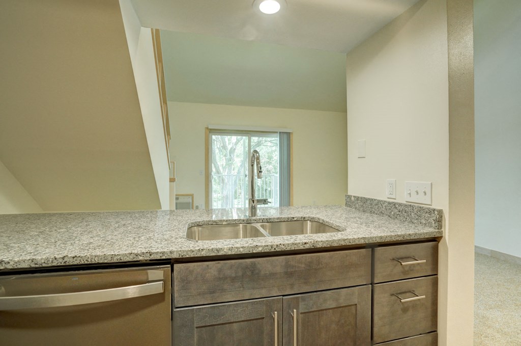 the kitchen has granite counter tops and stainless steel appliances