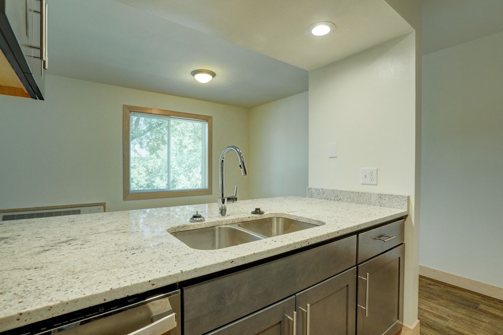 an empty kitchen with a sink and a window