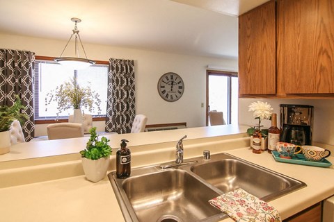a kitchen with a sink and a clock on the wall