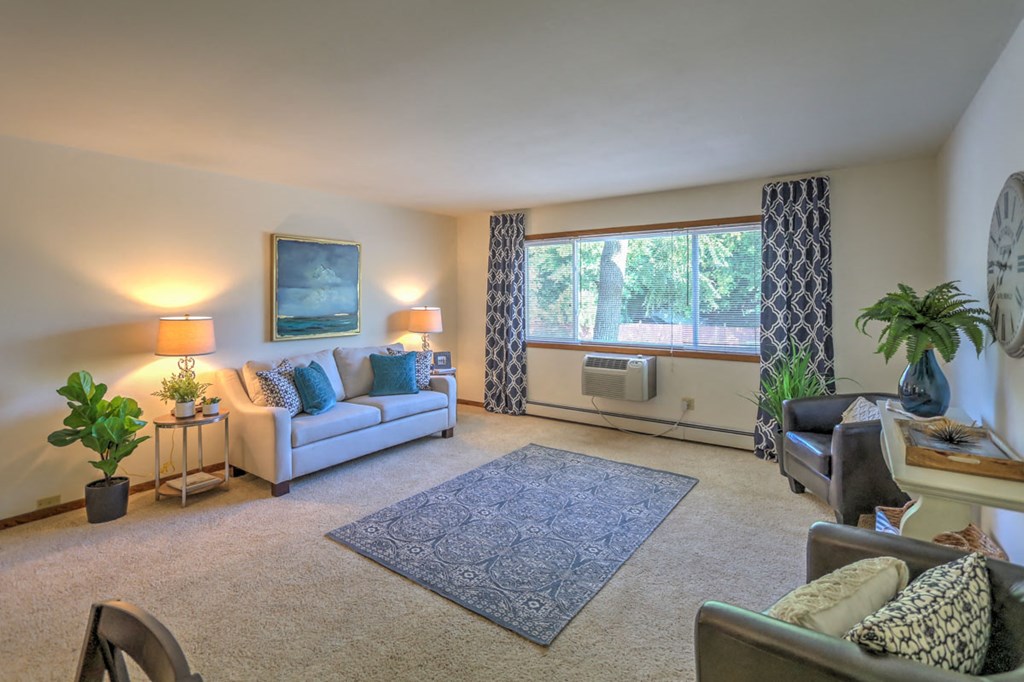 a living room with couches and chairs and a rug