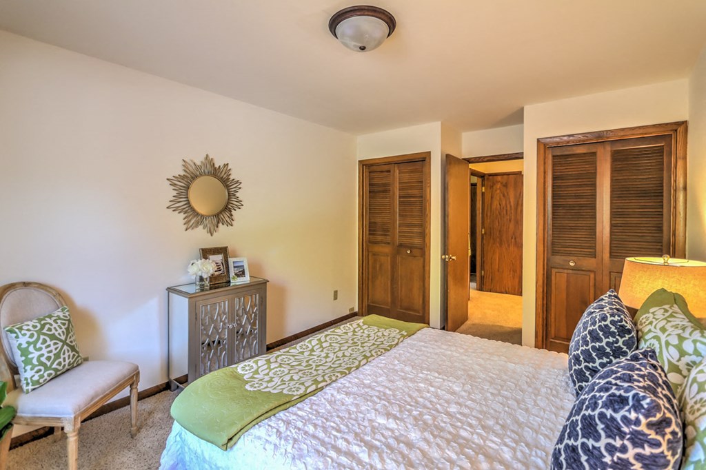 a bedroom with a bed and a door to a bathroom