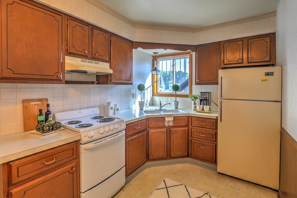a kitchen with white appliances and wooden cabinets