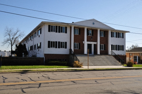 a large white building with steps in front of a street