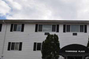 a white building with an awning in front of a parking lot