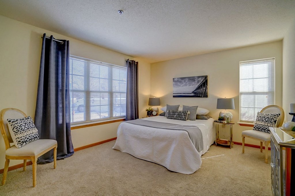 a bedroom with a bed and two windows