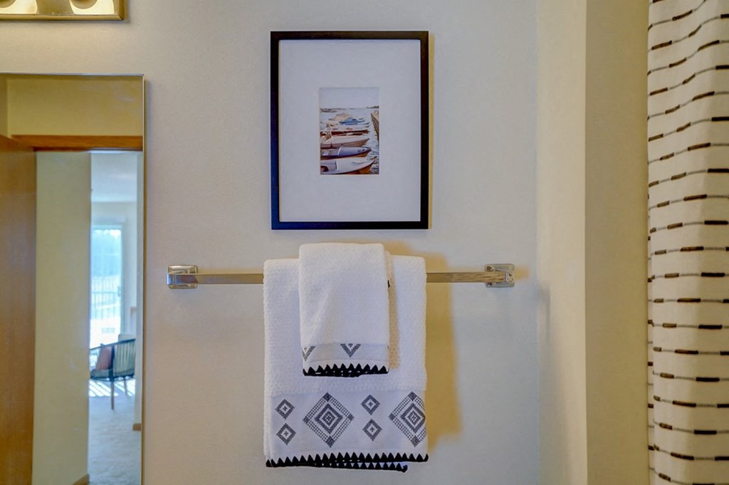a towel rack with two towels and a picture on the wall