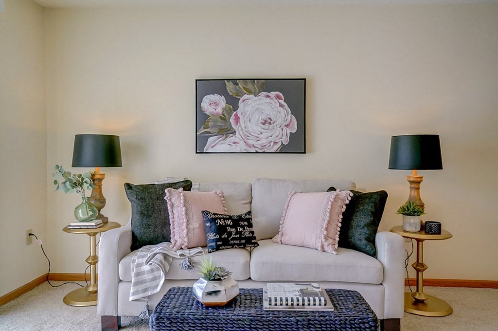 a living room with a white couch and a picture of flowers