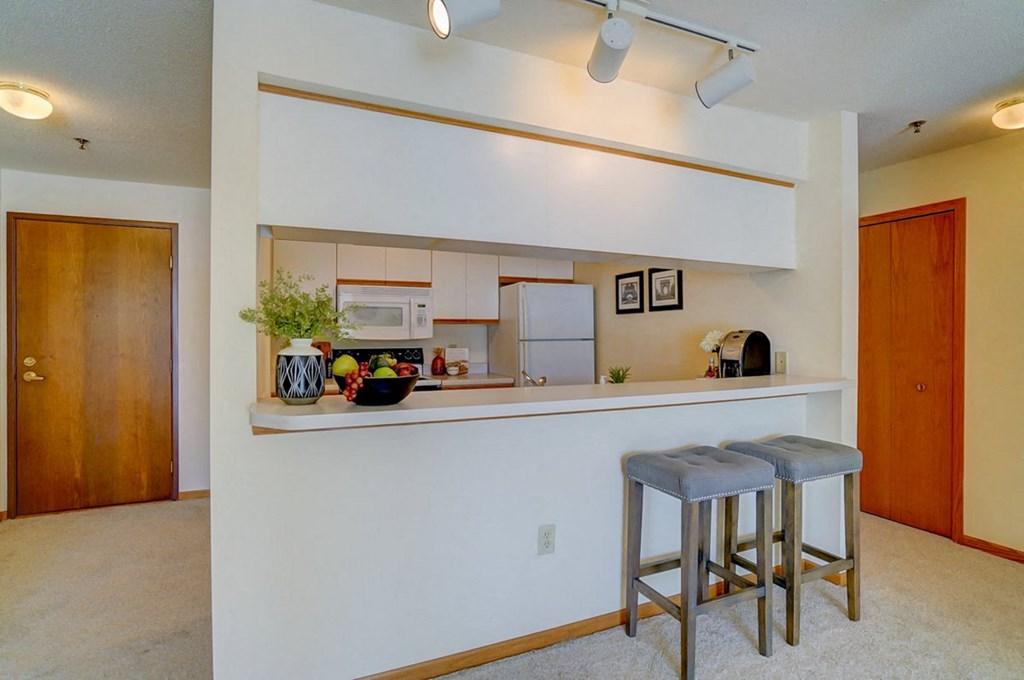 a kitchen with a bar with two stools
