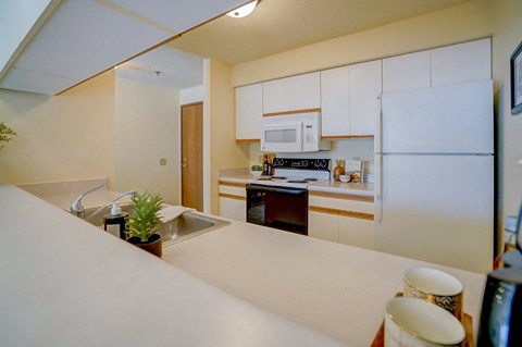 a kitchen with white cabinets and a sink and a refrigerator